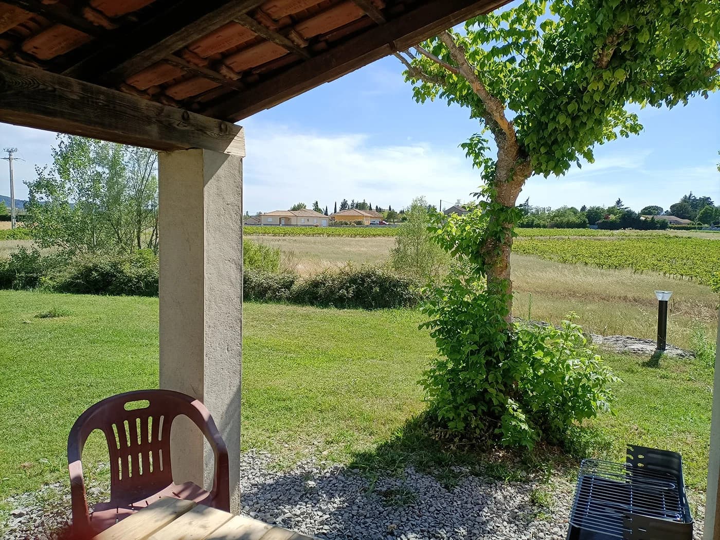 Terrasse couverte du gîte avec vue sur les vignes et la vallée